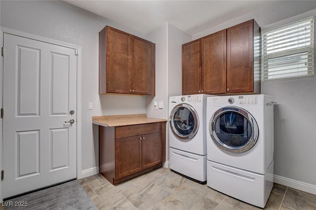 washroom with washer and clothes dryer and cabinets