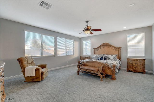 bedroom featuring ceiling fan, light carpet, and multiple windows