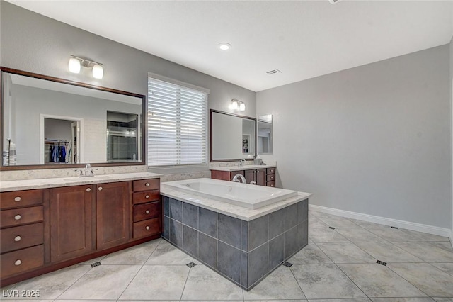 bathroom with vanity, tile patterned floors, and tiled tub