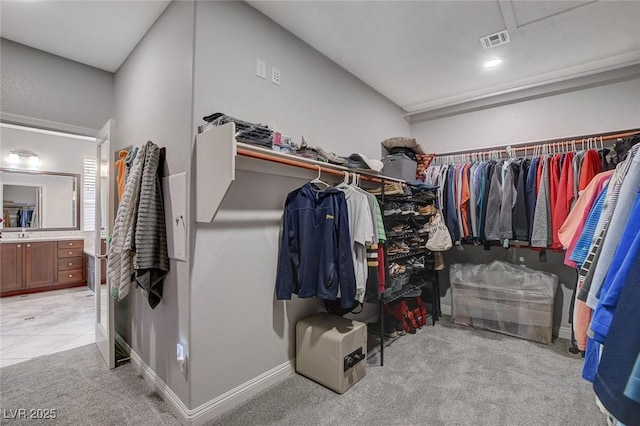 walk in closet with light carpet and sink