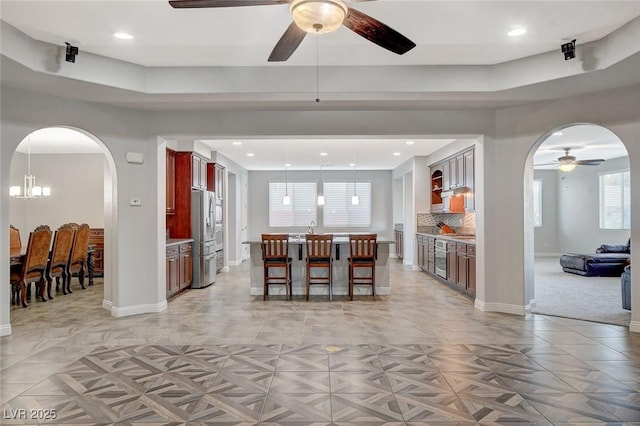 dining space with ceiling fan with notable chandelier, light parquet flooring, and sink