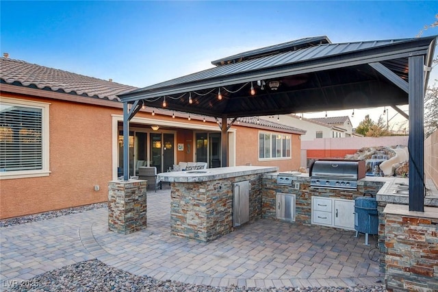 view of patio / terrace featuring a gazebo, an outdoor kitchen, and grilling area