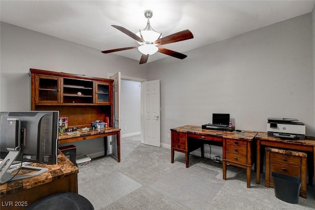 carpeted home office featuring ceiling fan