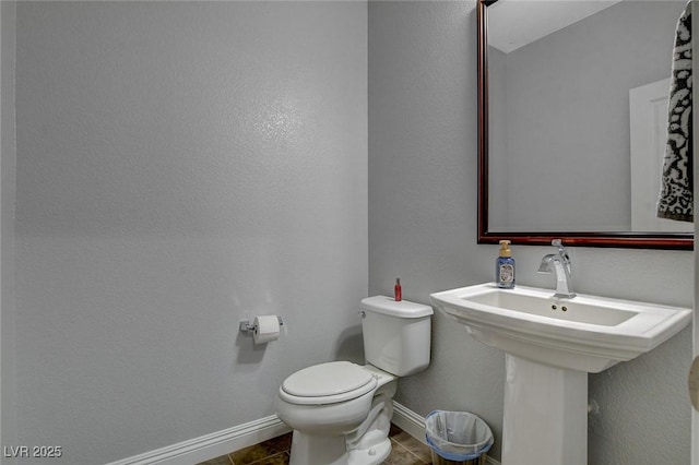 bathroom featuring toilet and tile patterned flooring