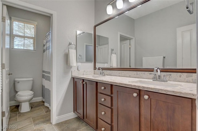 bathroom featuring toilet, vanity, and a shower with curtain