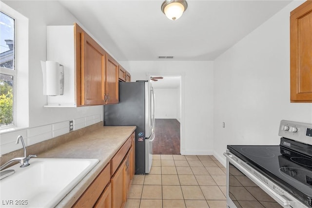 kitchen featuring light tile patterned floors, appliances with stainless steel finishes, sink, and tasteful backsplash