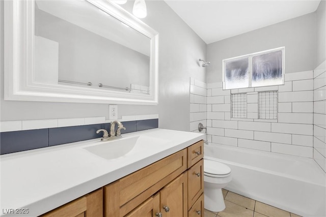 full bathroom with toilet, tile patterned flooring, tiled shower / bath combo, and vanity