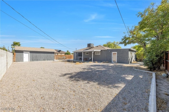 rear view of property with an outbuilding and central AC