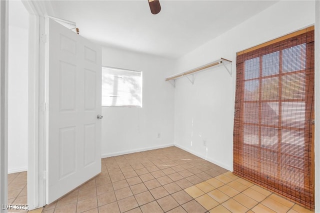 empty room featuring ceiling fan and light tile patterned floors