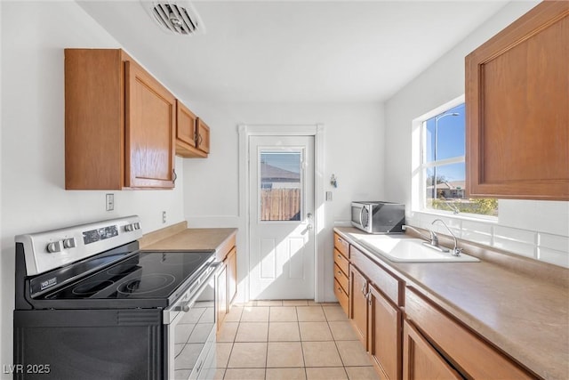 kitchen with light tile patterned floors, sink, and stainless steel appliances