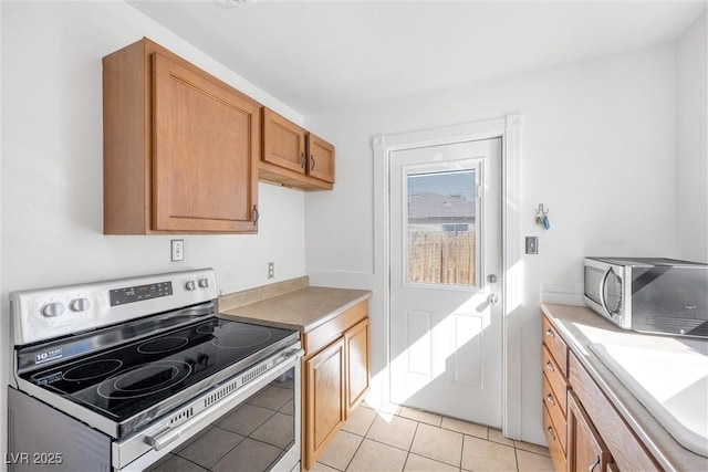 kitchen featuring light tile patterned floors, stainless steel appliances, and sink