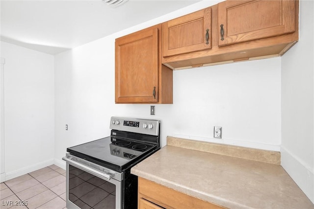 kitchen with light tile patterned flooring and stainless steel range with electric cooktop