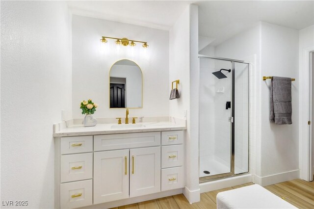 bathroom with vanity, wood-type flooring, and an enclosed shower