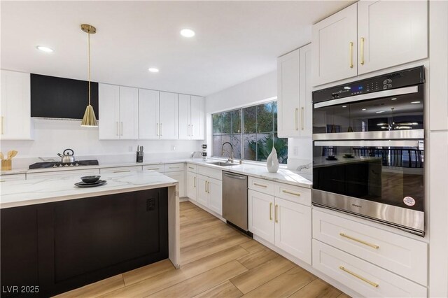 kitchen with light stone countertops, pendant lighting, white cabinets, and stainless steel appliances