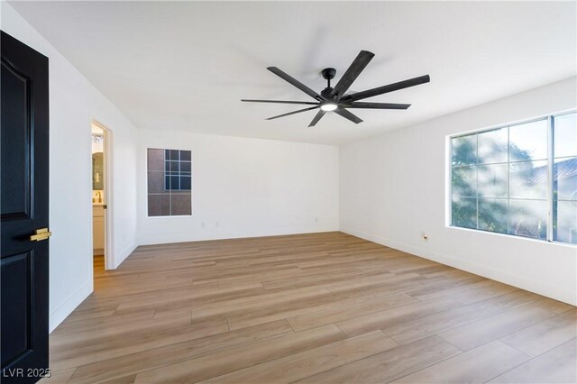 spare room with ceiling fan and light wood-type flooring