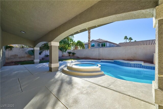 view of swimming pool featuring an in ground hot tub and a patio