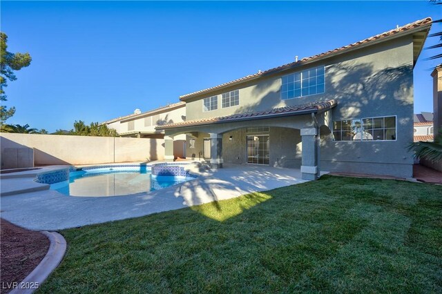 back of property featuring a fenced in pool, a yard, and a patio