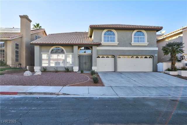 mediterranean / spanish home with a garage