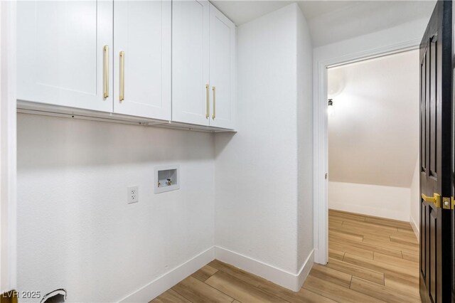 washroom with washer hookup and cabinets