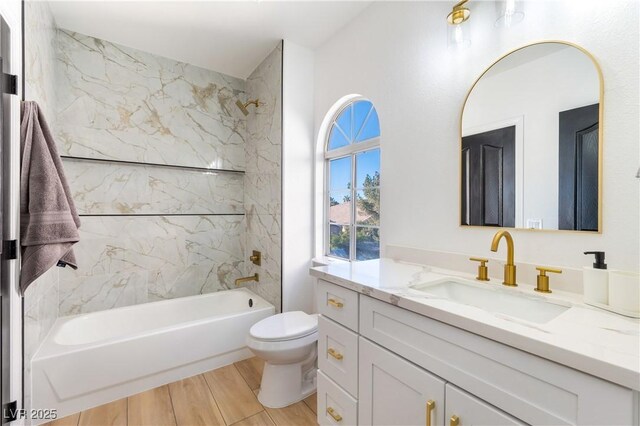 full bathroom with toilet, vanity, and tiled shower / bath