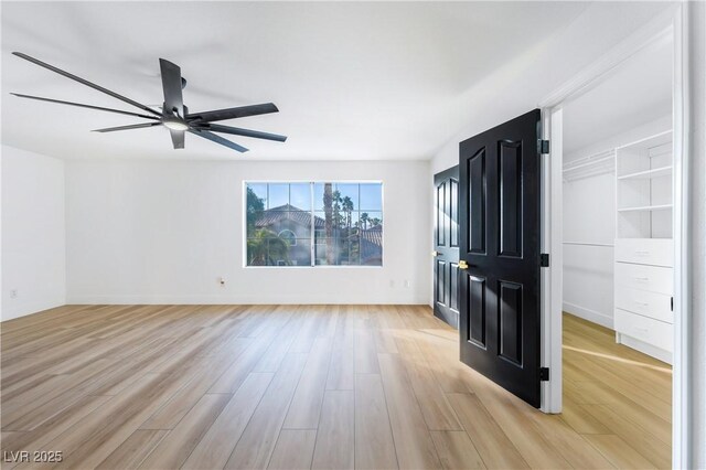 unfurnished living room featuring ceiling fan and light wood-type flooring