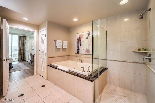 bathroom with independent shower and bath and tile patterned floors