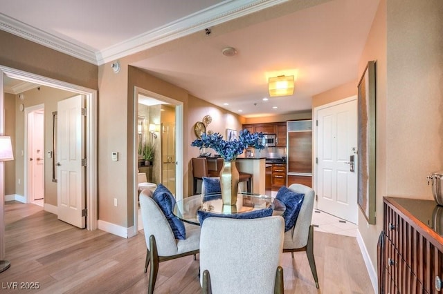 dining room featuring crown molding and light hardwood / wood-style floors