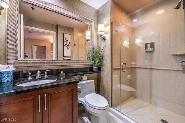 bathroom featuring toilet, tile walls, a shower with shower door, and vanity