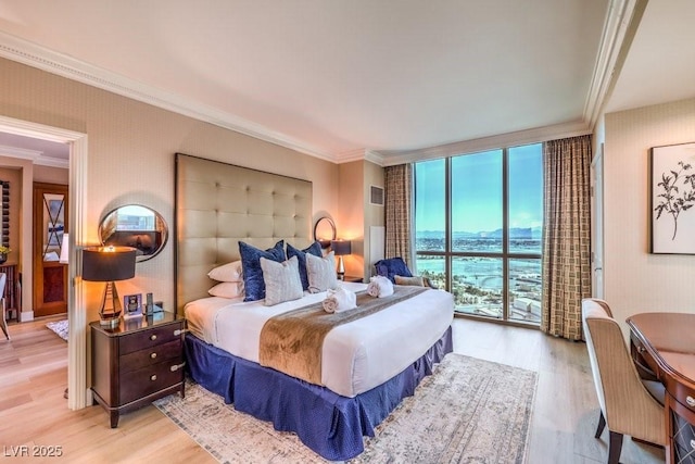 bedroom featuring access to outside, ornamental molding, floor to ceiling windows, and light hardwood / wood-style flooring