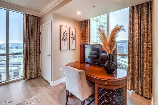 office area with light hardwood / wood-style floors and ornamental molding