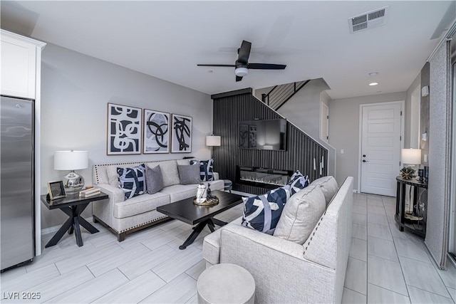 living room featuring ceiling fan and a fireplace