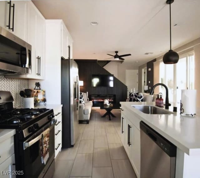 kitchen with ceiling fan, pendant lighting, sink, white cabinetry, and appliances with stainless steel finishes