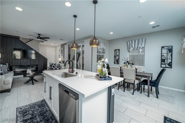 kitchen featuring ceiling fan, dishwasher, sink, hanging light fixtures, and white cabinets