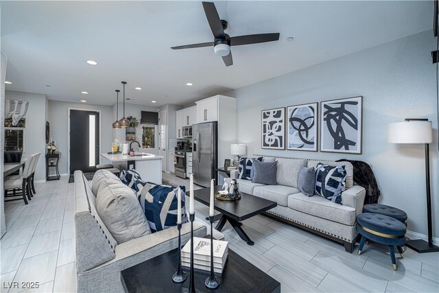 living room with ceiling fan and sink