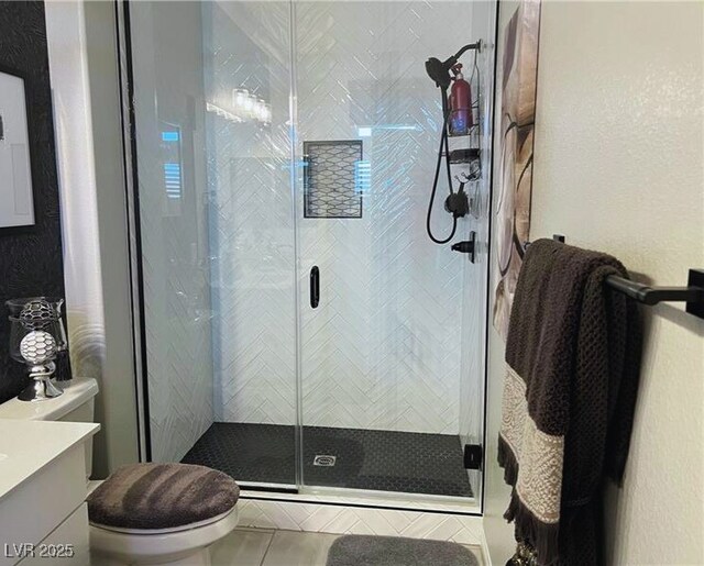 bathroom with toilet, vanity, tile patterned flooring, and walk in shower