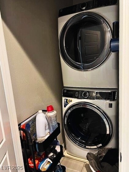 laundry area featuring tile patterned flooring and stacked washer and dryer