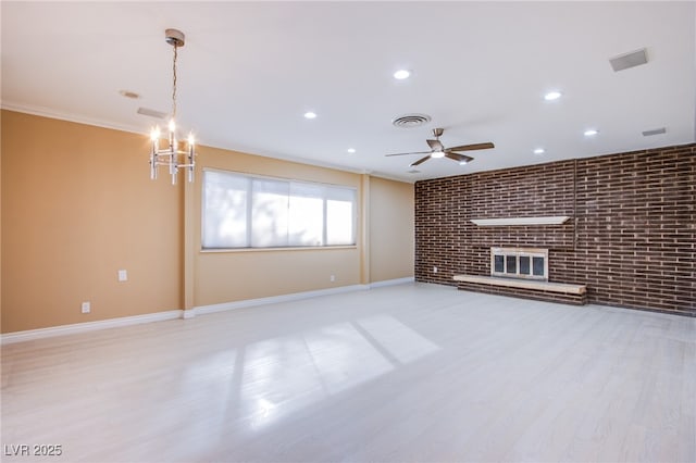 unfurnished living room featuring light hardwood / wood-style floors, a brick fireplace, brick wall, ornamental molding, and ceiling fan with notable chandelier