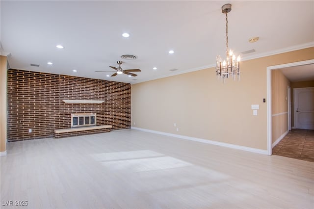 unfurnished living room featuring brick wall, a fireplace, ceiling fan with notable chandelier, and crown molding