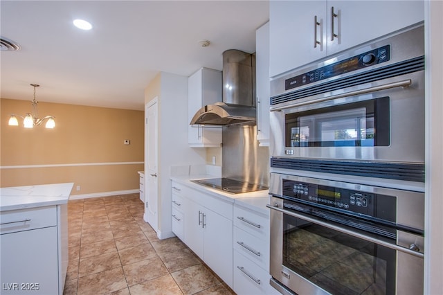 kitchen featuring an inviting chandelier, white cabinets, wall chimney exhaust hood, and black electric stovetop