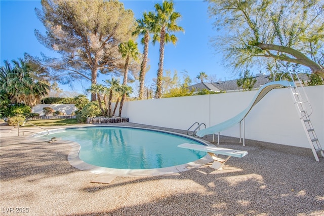 view of swimming pool featuring a water slide and a diving board