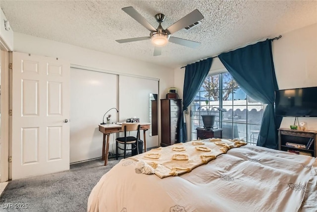 carpeted bedroom featuring a textured ceiling, ceiling fan, and a closet