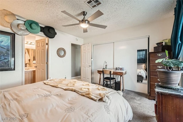 bedroom featuring carpet, ceiling fan, a closet, and a textured ceiling