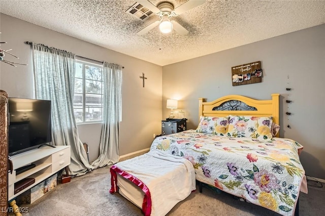 carpeted bedroom featuring ceiling fan and a textured ceiling