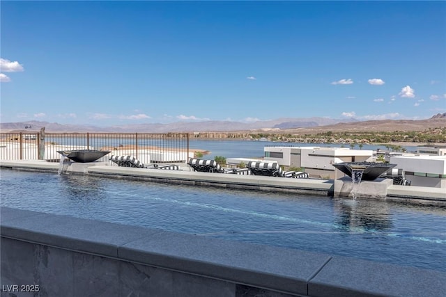 exterior space with fence and a water and mountain view