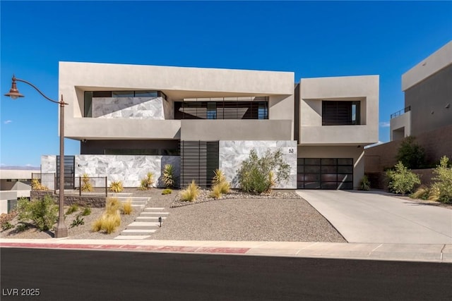 contemporary house with driveway, stairway, an attached garage, and stucco siding