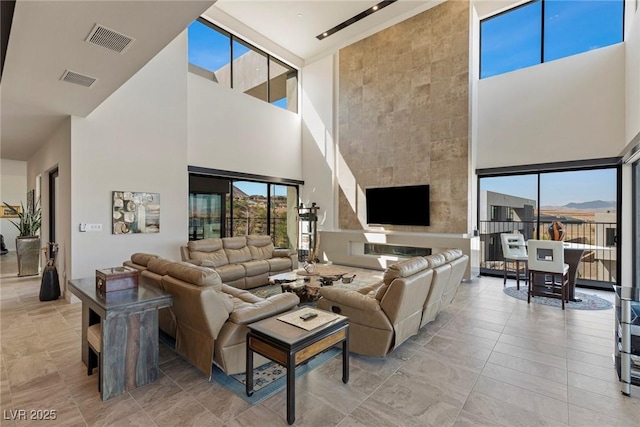 living room featuring a high ceiling and a tile fireplace