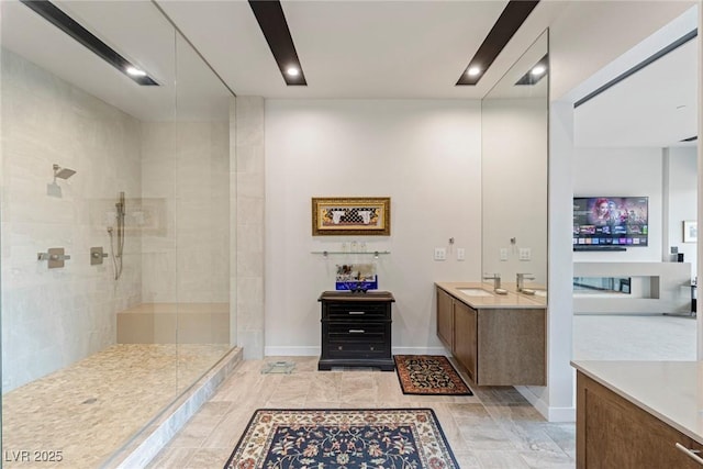 bathroom with vanity, baseboards, and walk in shower