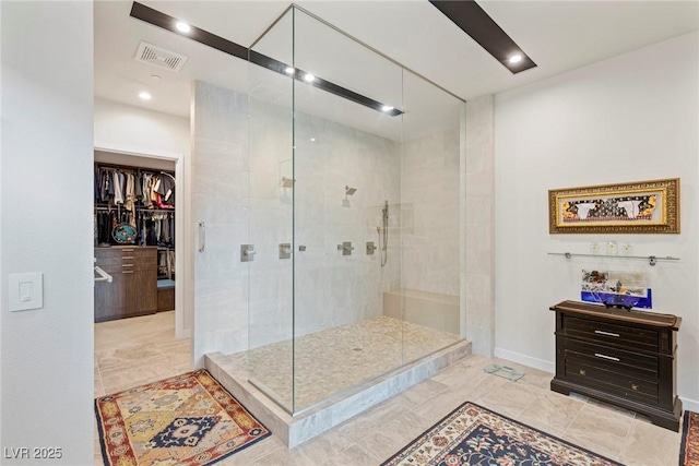 bathroom with recessed lighting, visible vents, a spacious closet, a stall shower, and baseboards