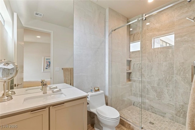 bathroom with toilet, a stall shower, vanity, and visible vents