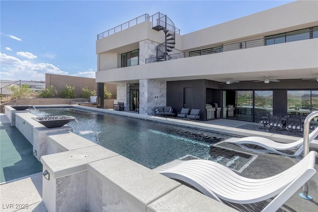 view of swimming pool with ceiling fan, pool water feature, and a patio